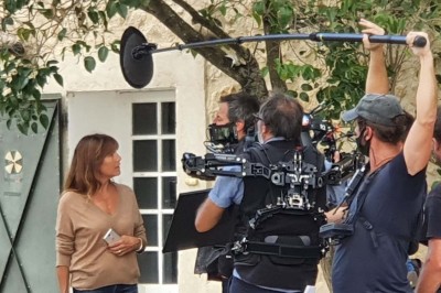 Chambre avec lit double bleu, tête de lit en rotin, décoration sobre et tableau représentant un ponton sur la mer.