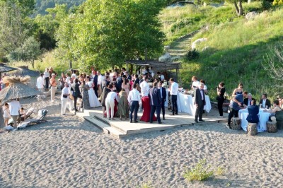 Chambre avec lit double bleu, tête de lit en rotin, décoration sobre et tableau représentant un ponton sur la mer.