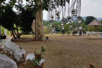 Chambre avec lit double bleu, tête de lit en rotin, décoration sobre et tableau représentant un ponton sur la mer.
