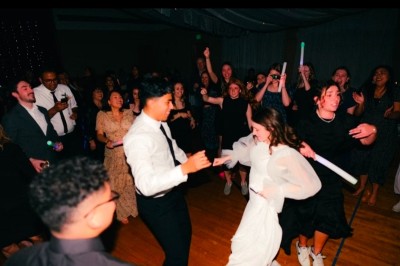 Miniature DJ Melun (Seine-et-Marne) - Dj Urya #6 Un couple s'embrasse sous une arche, entouré d'invités tenant des cierges magiques allumés dans l'obscurité.