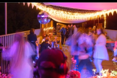 Miniature DJ Melun (Seine-et-Marne) - Dj Urya #8 Un couple s'embrasse sous une arche, entouré d'invités tenant des cierges magiques allumés dans l'obscurité.