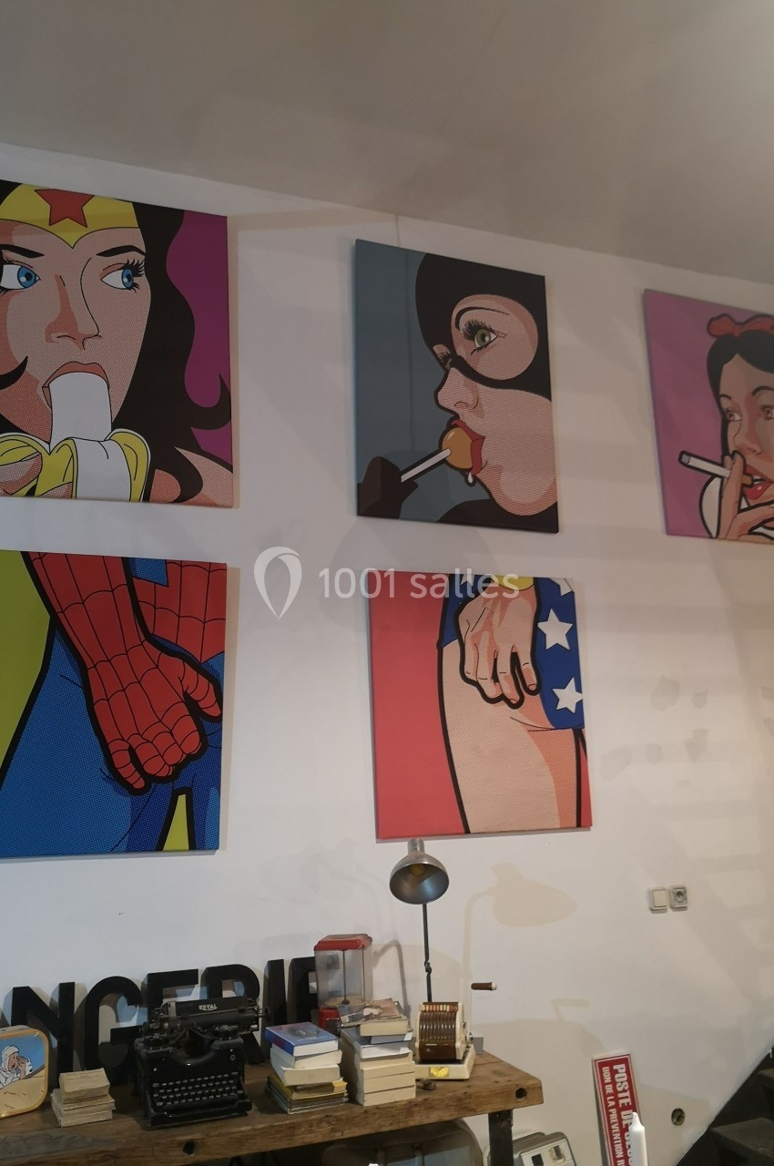 Quatre tableaux pop art représentant des personnages féminins et masculins dans un style coloré accrochés sur un mur.