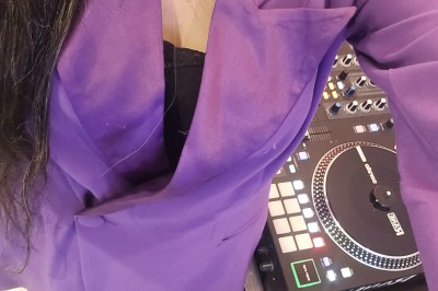 Miniature DJ Le Mée-sur-Seine (Seine-et-Marne) - Dj Urya #11 Une DJ en robe verte mixe de la musique sur une table de mixage dans un décor lumineux avec des fleurs de cerisier.