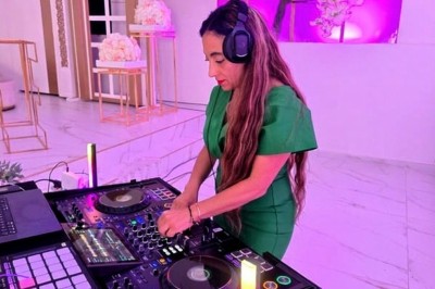 Miniature DJ Le Mée-sur-Seine (Seine-et-Marne) - Dj Urya #18 Une DJ en robe verte mixe de la musique sur une table de mixage dans un décor lumineux avec des fleurs de cerisier.