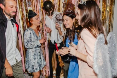 Femme devant une table de mixage avec ordinateurs, dans une salle où se déroule un événement sportif ou culturel.