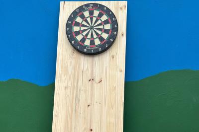 Trois valises vintage empilées, en cuir et tissu, posées sur une surface en extérieur avec de l'herbe en arrière-plan.