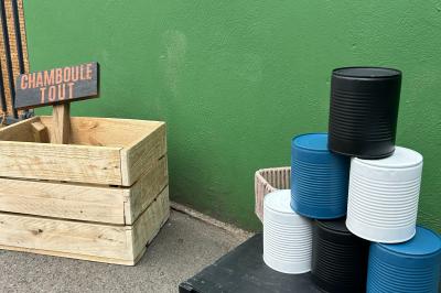 Trois valises vintage empilées, en cuir et tissu, posées sur une surface en extérieur avec de l'herbe en arrière-plan.