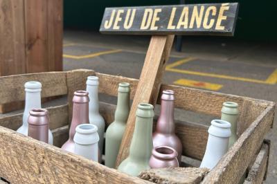 Trois valises vintage empilées, en cuir et tissu, posées sur une surface en extérieur avec de l'herbe en arrière-plan.