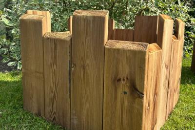 Trois valises vintage empilées, en cuir et tissu, posées sur une surface en extérieur avec de l'herbe en arrière-plan.