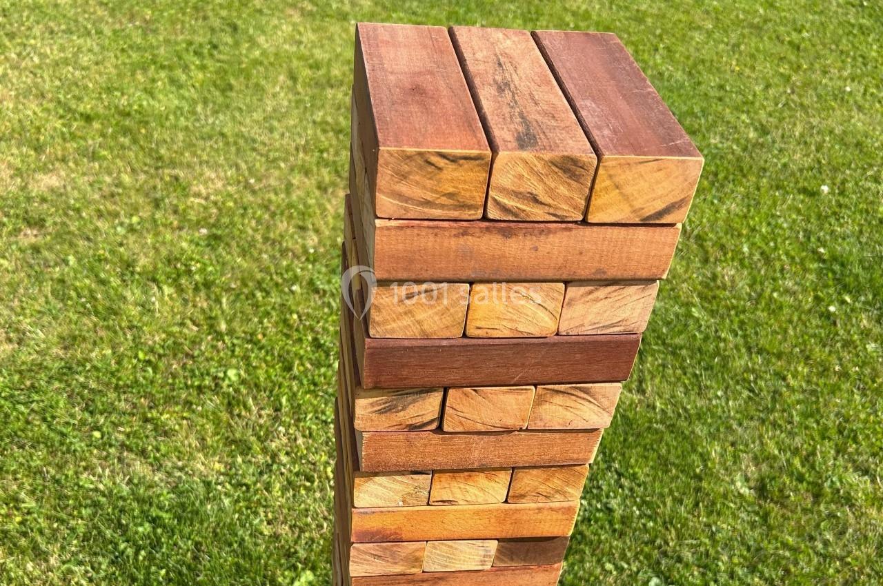 Tour de blocs en bois empilés sur une pelouse verte, vue en plongée.