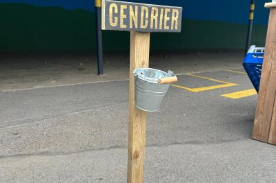 Trois valises vintage empilées, en cuir et tissu, posées sur une surface en extérieur avec de l'herbe en arrière-plan.