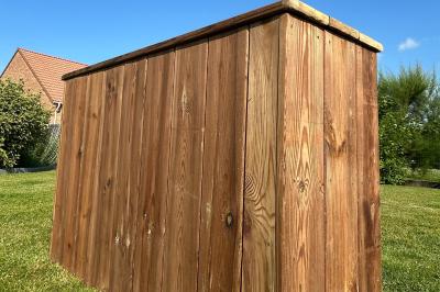 Trois valises vintage empilées, en cuir et tissu, posées sur une surface en extérieur avec de l'herbe en arrière-plan.