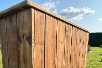 Trois valises vintage empilées, en cuir et tissu, posées sur une surface en extérieur avec de l'herbe en arrière-plan.