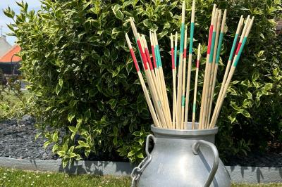 Trois valises vintage empilées, en cuir et tissu, posées sur une surface en extérieur avec de l'herbe en arrière-plan.