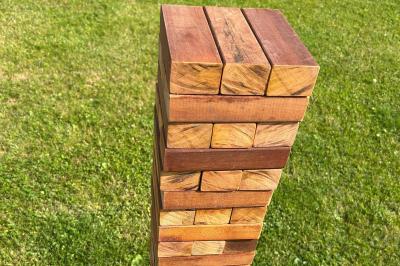 Trois valises vintage empilées, en cuir et tissu, posées sur une surface en extérieur avec de l'herbe en arrière-plan.