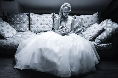 Miniature Victor Podgorski Photographe #3 Un couple en tenue de mariage s'embrasse dans un champ de blé, tenant des ballons colorés sous un ciel bleu.