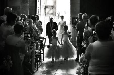 Miniature Victor Podgorski Photographe #10 Un couple en tenue de mariage s'embrasse dans un champ de blé, tenant des ballons colorés sous un ciel bleu.