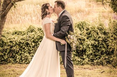 Miniature Amanda Pictures #6 Un couple en tenue de mariage danse dans un jardin baigné par une lumière dorée.