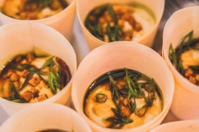 Miniature Traiteur Boulogne-Billancourt (Hauts-de-Seine) - Bellota Bellota #4 Tentacules de poulpe en train de cuire dans une poêle, manipulés avec une pince en métal.