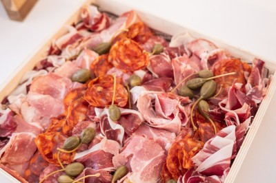 Tentacules de poulpe grillés dans une poêle chaude, manipulés avec une pince en cuisine.