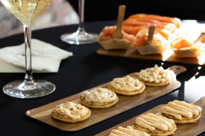 Tentacules de poulpe grillés dans une poêle chaude, manipulés avec une pince en cuisine.