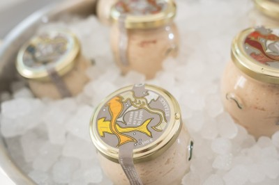 Tentacules de poulpe grillés dans une poêle chaude, manipulés avec une pince en cuisine.