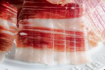 Tentacules de poulpe grillés dans une poêle chaude, manipulés avec une pince en cuisine.