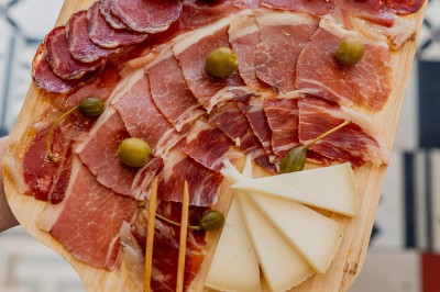 Tentacules de poulpe grillés dans une poêle chaude, manipulés avec une pince en cuisine.