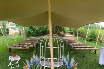 Salle de réunion lumineuse avec table en bois, chaises rembourrées, bouteilles d'eau et grandes fenêtres avec rideaux…
