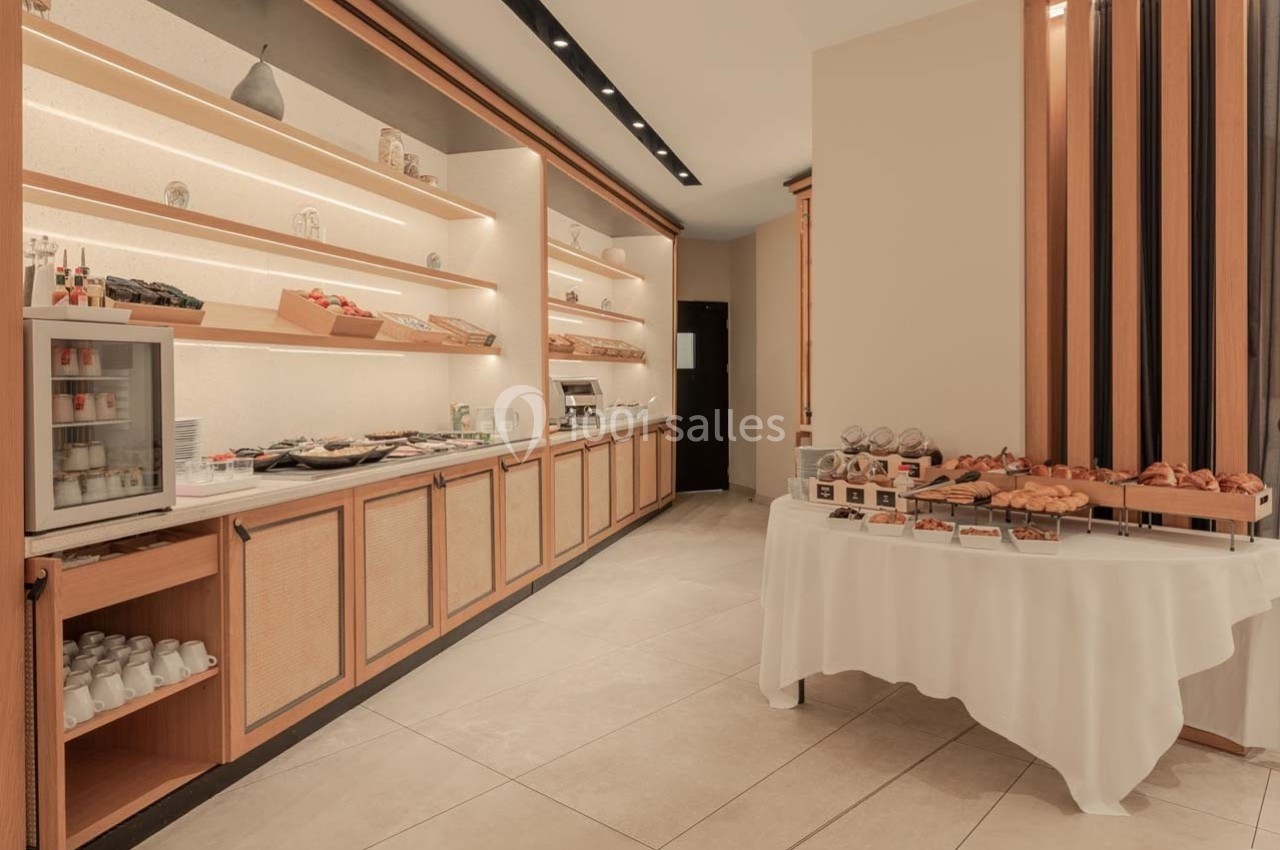 Buffet de petit-déjeuner avec viennoiseries, pains, fruits et boissons disposés sur des étagères et une table.