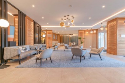 Miniature Location salle Saint-Laurent-du-Var (Alpes-Maritimes) - Holiday Inn Nice Port Saint Laurent #33 Espace lounge moderne avec fauteuils, canapés, tapis bleu et éclairage design dans un intérieur lumineux et chaleureux.