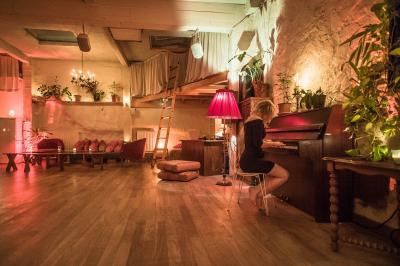 Miniature Location salle Paris 17 (Paris) - Loft Lechapelais #2 Salle spacieuse avec éclairage tamisé orange, murs en pierre, bancs en bois et décorations végétales.