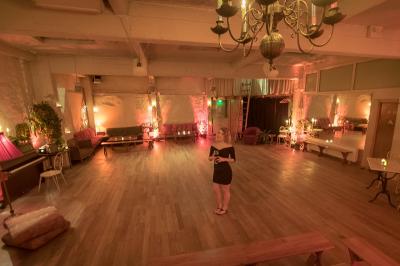 Miniature Location salle Paris 17 (Paris) - Loft Lechapelais #5 Salle spacieuse avec éclairage tamisé orange, murs en pierre, bancs en bois et décorations végétales.