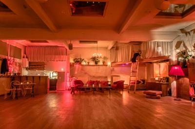 Miniature Location salle Paris 17 (Paris) - Loft Lechapelais #4 Salle spacieuse avec éclairage tamisé orange, murs en pierre, bancs en bois et décorations végétales.