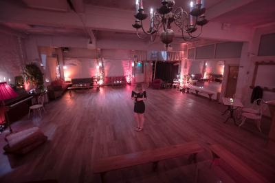 Miniature Location salle Paris 17 (Paris) - Loft Lechapelais #6 Salle spacieuse avec éclairage tamisé orange, murs en pierre, bancs en bois et décorations végétales.