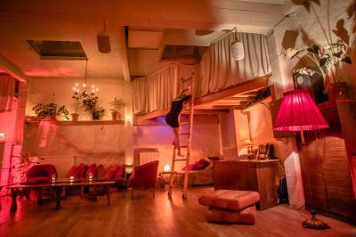 Miniature Location salle Paris 17 (Paris) - Loft Lechapelais #14 Salle spacieuse avec éclairage tamisé orange, murs en pierre, bancs en bois et décorations végétales.