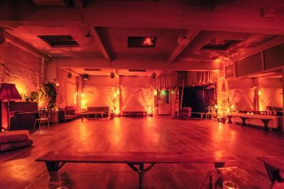 Miniature Location salle Paris 17 (Paris) - Loft Lechapelais #15 Salle spacieuse avec éclairage tamisé orange, murs en pierre, bancs en bois et décorations végétales.