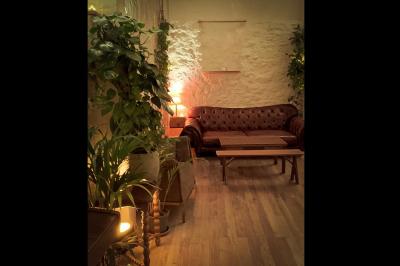 Miniature Location salle Paris 17 (Paris) - Loft Lechapelais #7 Salle spacieuse avec éclairage tamisé orange, murs en pierre, bancs en bois et décorations végétales.