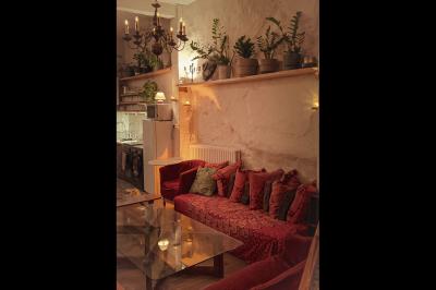 Miniature Location salle Paris 17 (Paris) - Loft Lechapelais #8 Salle spacieuse avec éclairage tamisé orange, murs en pierre, bancs en bois et décorations végétales.