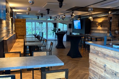 Miniature Location salle Braine-l'Alleud (Brabant wallon) - Le Moulin Blanc #2 Salle lumineuse avec parquet clair, table et chaises au centre, escalier blanc, machine à coudre ancienne et tableau au mur.