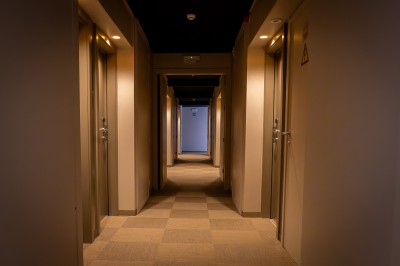 Une main verse un cocktail rose dans un verre décoré d'une tranche de citron vert, avec des boissons et snacks en arrière…