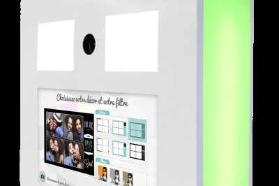 Borne photo interactive avec écran tactile, éclairage LED vert et options de filtres affichées sur l'écran.