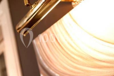 Lustre en cristal allumé suspendu au-dessus d'un escalier avec rampe en fer forgé et sol en marbre.