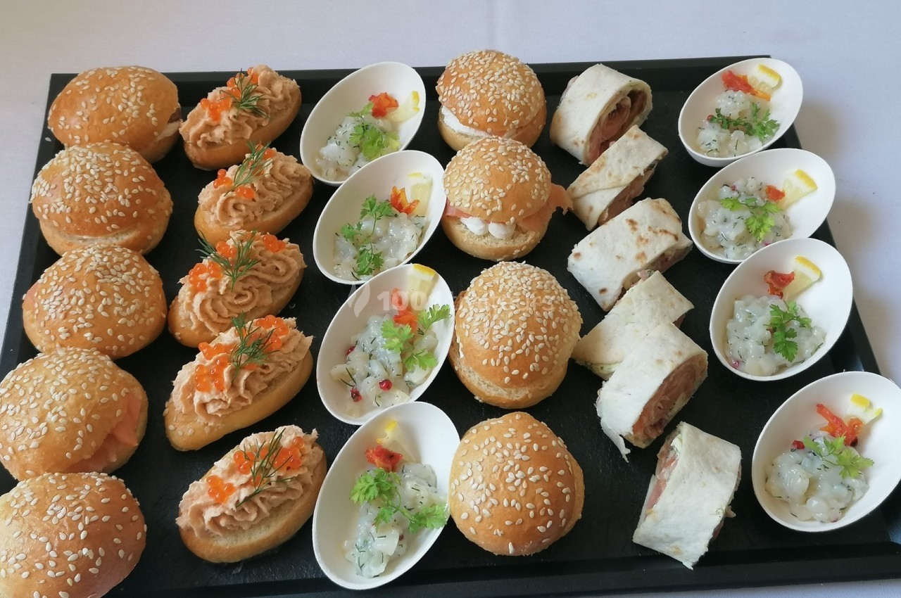 Plateau de bouchées apéritives variées comprenant mini-burgers, wraps et verrines de salade colorée.