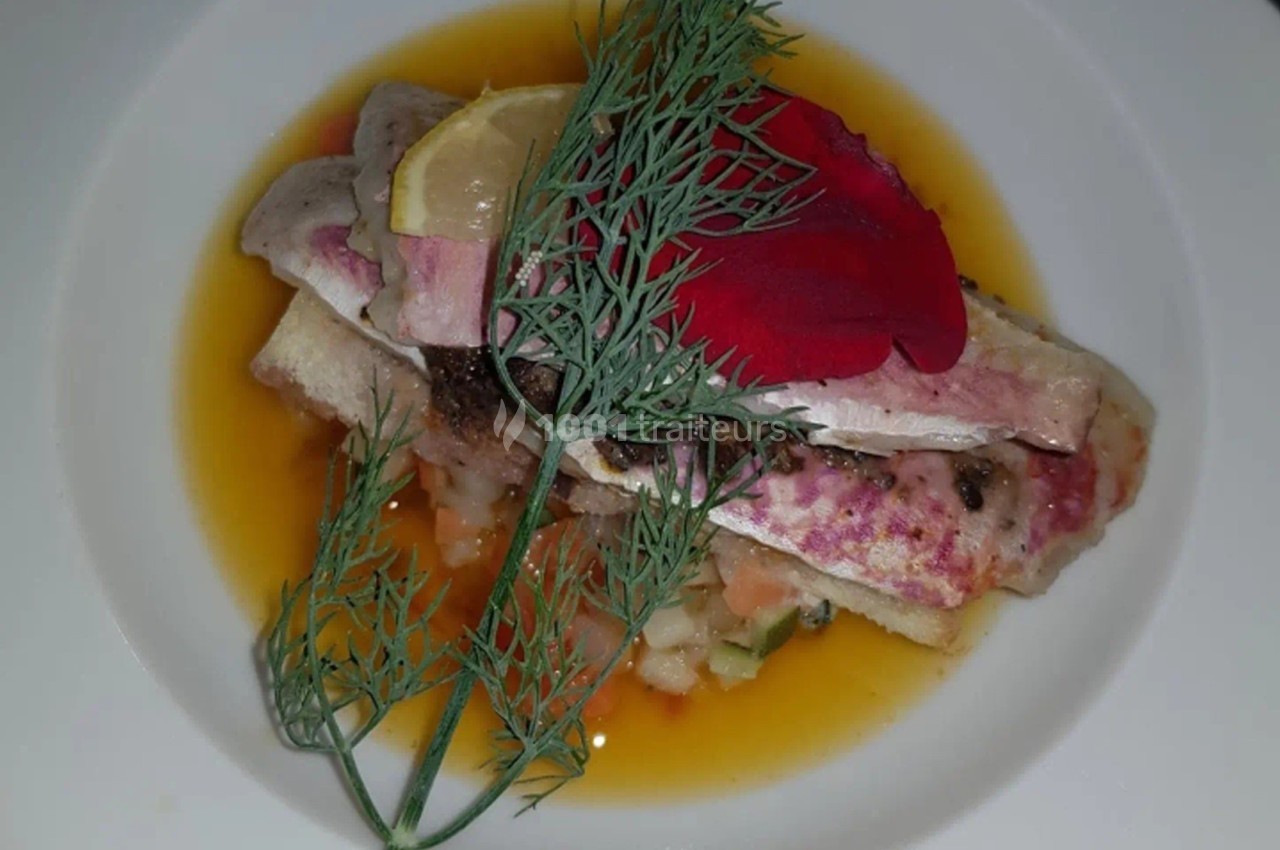 Filets de poisson dressés sur un lit de légumes, nappés de sauce, garnis d'aneth, d'une tranche de citron et d'un pétale…