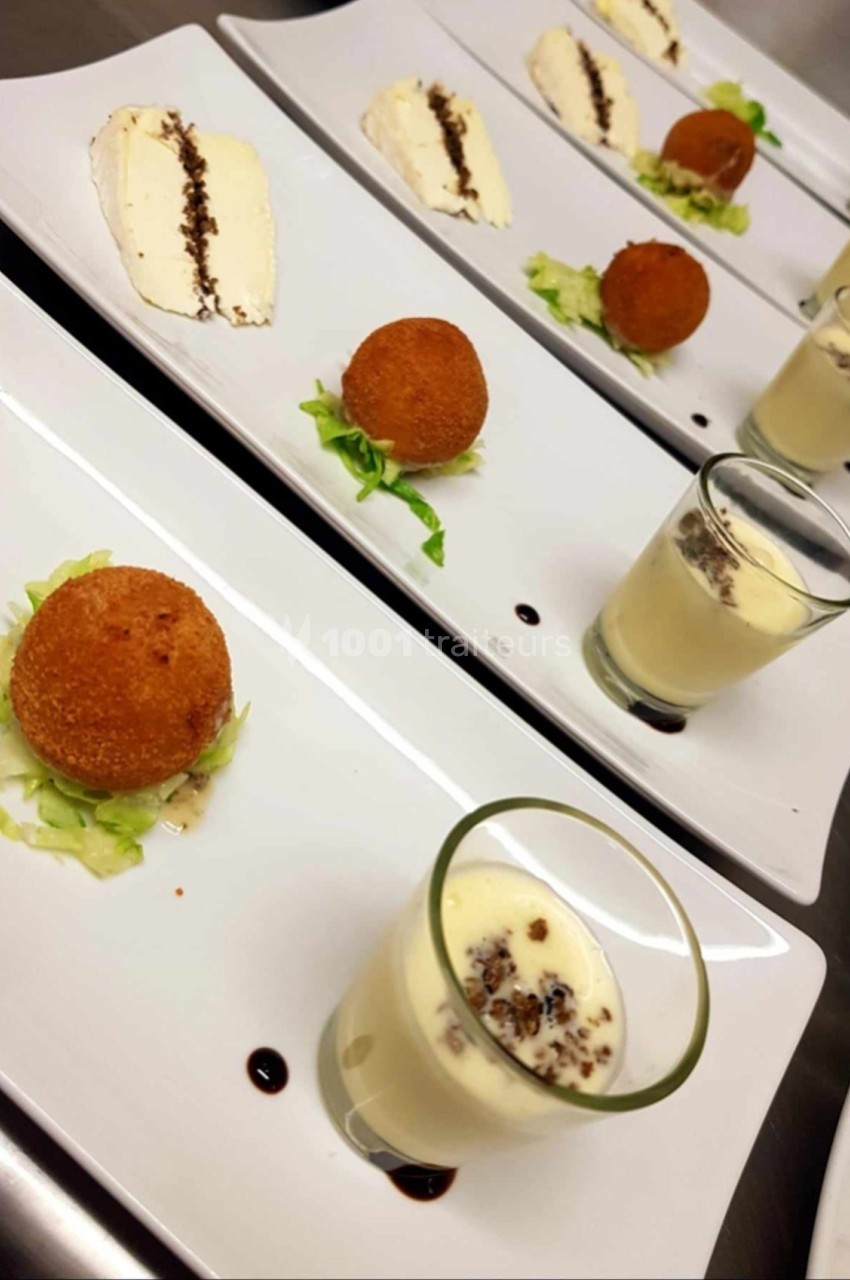 Assiette de dégustation avec croquettes, mousse en verrine et tranche de fromage, présentées sur lit de salade.