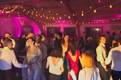 Miniature DJ Heyrieux (Isère) - Ld Animations #9 Un couple en tenue de mariage danse dans une salle éclairée par des lumières colorées et entourée de fumée.