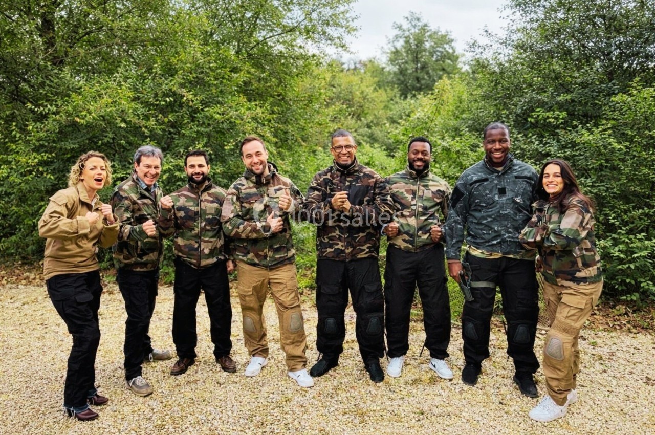Un groupe de personnes en tenue de camouflage pose debout sur un chemin, entouré de végétation.