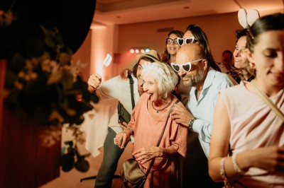 Appareil photo sur trépied en bois avec lampe circulaire, installé dans un jardin verdoyant.