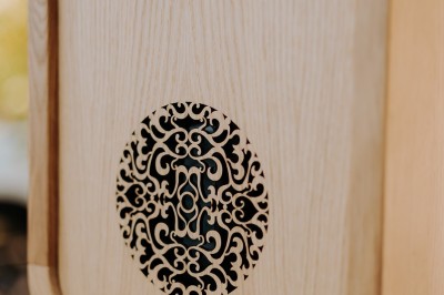 Miniature Lively Booth #4 Appareil photo en bois monté sur un trépied, installé dans un jardin avec des arbres en arrière-plan.